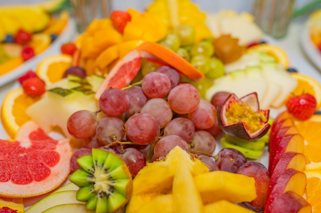 A variety of fresh fruits including grapes, kiwis, and passionfruit in a vibrant, healthy display.