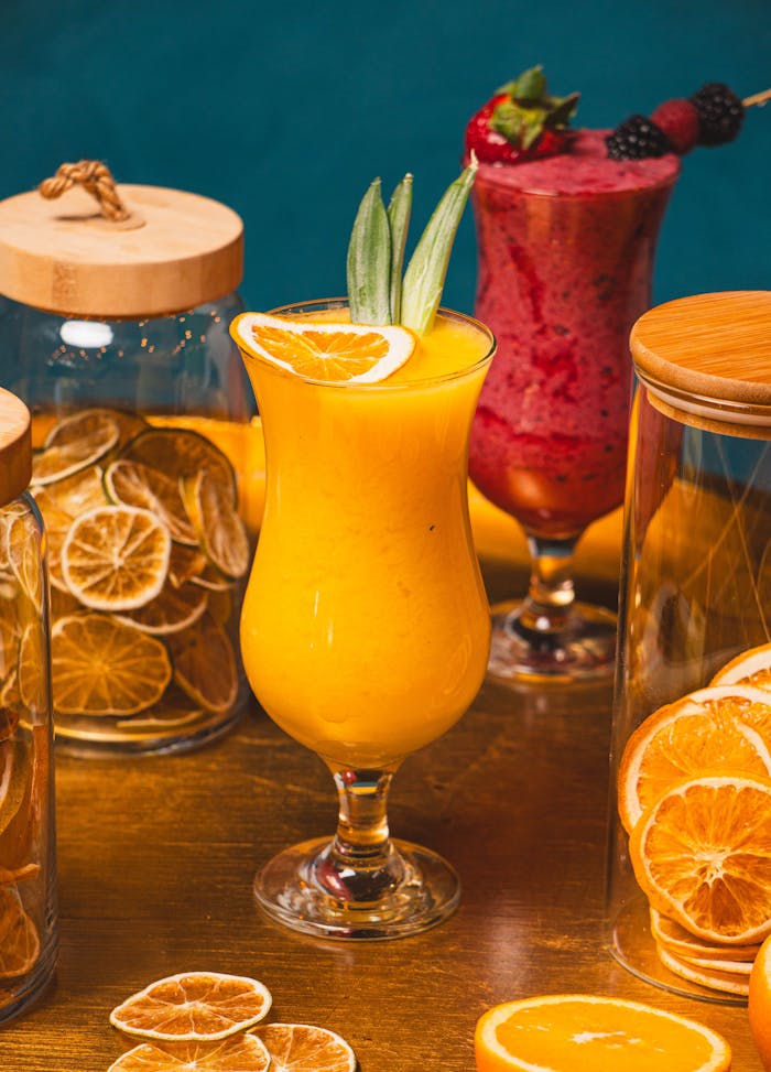 Colorful tropical and berry cocktails with fresh and dried fruit slices, perfect for a refreshing summer drink.